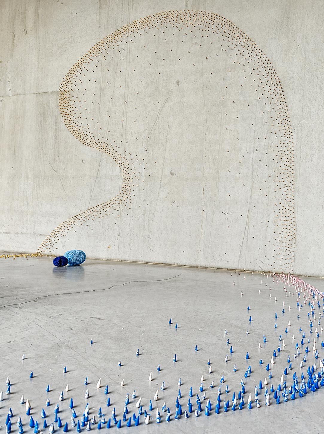 Groeivormen ceramic installation dispersed across wall, floor and stairs